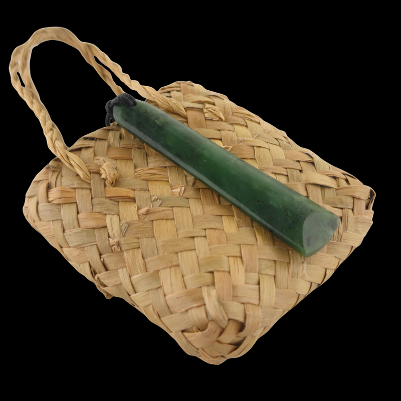 Woven basket with a green cylindrical object on a black background