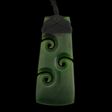 Green jade pendant with spiral designs on a black background
