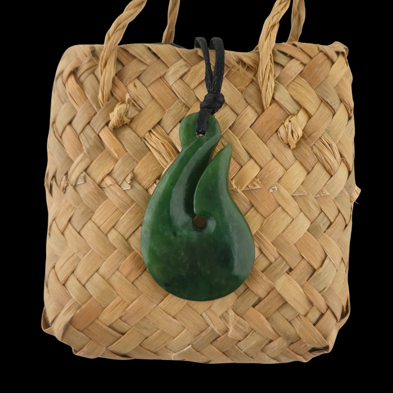 Woven basket with a green jade pendant on a black background