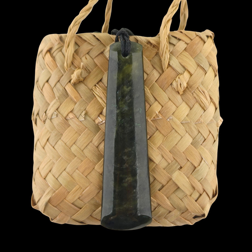 Woven basket with a dark green stone pendant on a black background
