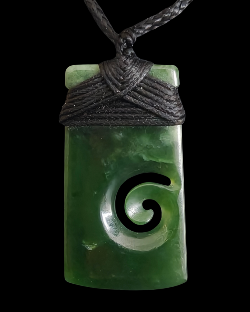 Green jade pendant with a spiral design on a black cord against a white background
