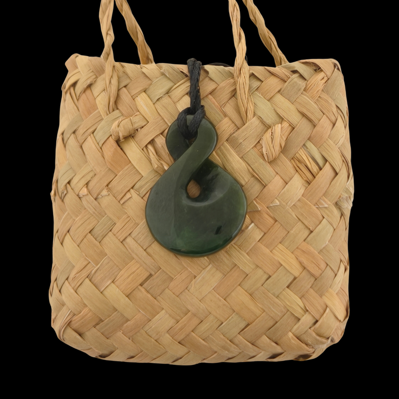 Woven bag with a green hook on a black background