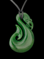 A green carved pendant necklace with a curved, polished design and a dark gray cord, shown against a solid black background.