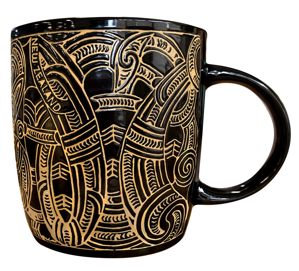 Black mug with gold intricate patterns on a white background