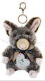 A plush toy rabbit keychain with a metal clasp and ring, featuring gray and brown fur, pink inner ears and paws, a cream snout, and a black ribbon with a heart-shaped tag that reads 'Po' and 'New Zealand'.