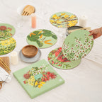 Set of floral placemats on a table with a hand holding one