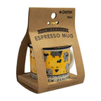 A New Zealand Espresso Mug in its original brown kraft paper packaging. The mug features a bright yellow body with black sheep illustrations and a black rim, with the word 'NEW ZEALAND' printed on the base.