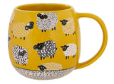 A yellow ceramic mug decorated with a pattern of stylized sheep in black, white, and yellow, featuring 'NEW ZEALAND' printed on the bottom rim.