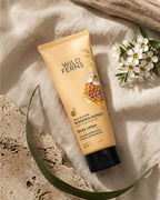 Wild Ferns New Zealand Manuka Honey Body Lotion on a textured surface with flowers and leaves.