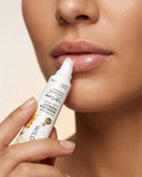 Person applying lip balm to their lips with a focus on the product.