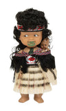 Doll dressed in traditional Maori attire with a white background