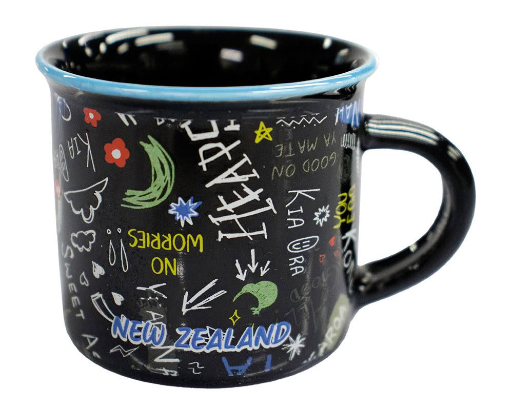 A black enamel mug with a light blue rim, decorated with colorful hand-drawn doodles and the words 'NEW ZEALAND' in blue. The mug is photographed on a clean white background.