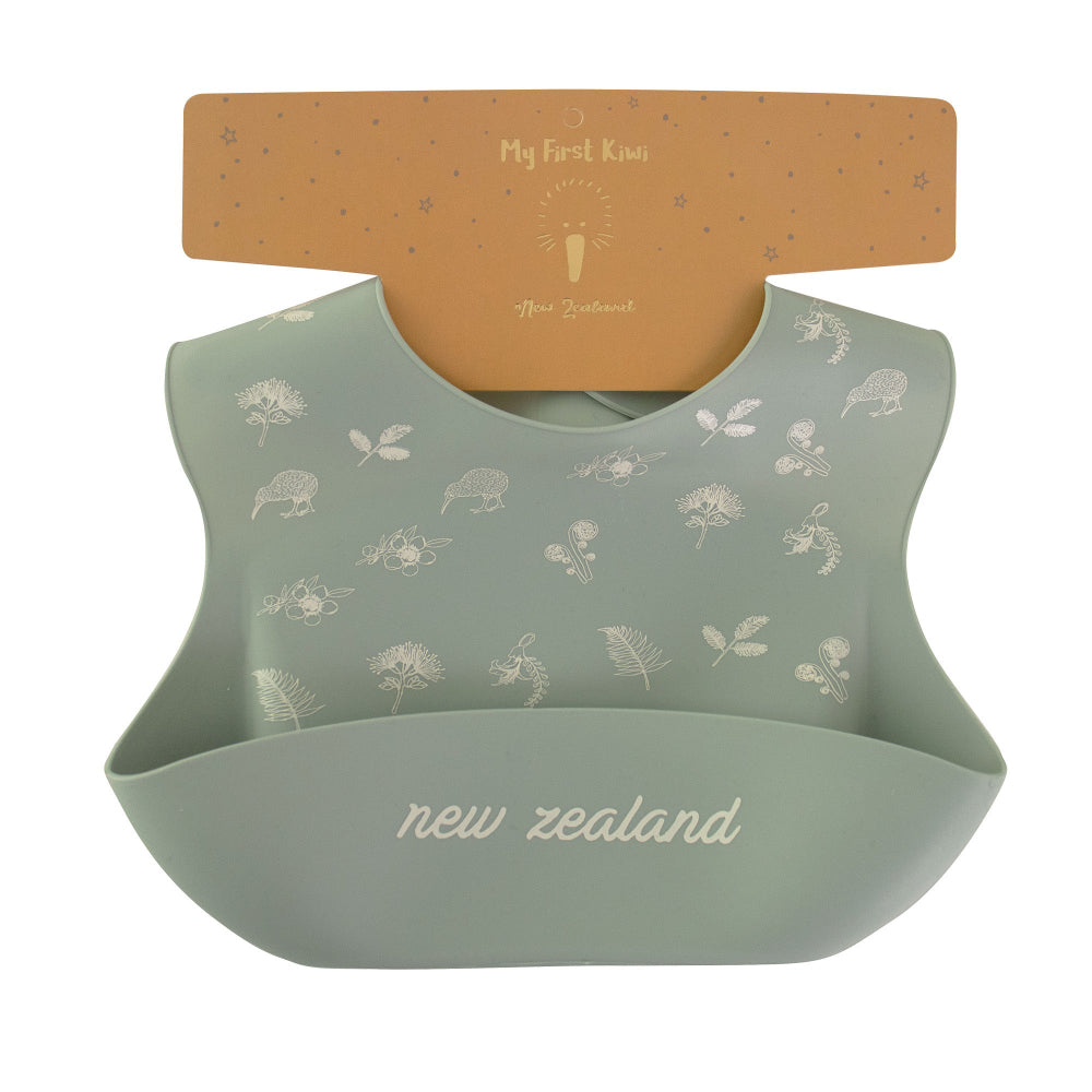 Grey baby bib with nature-themed print and 'New Zealand' text, displayed on a hanger.
