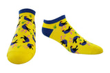 A pair of low-cut yellow socks with a navy blue cuff and toe, featuring a playful pattern of pukeko birds in blue, pink, and green, displayed on a clean white background.