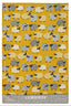 A woven tea towel featuring a repeating pattern of stylized sheep in black, white, and beige on a mustard yellow background, with a textured gray border at the bottom containing the text 'NEW ZEALAND'.
