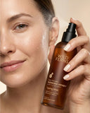 Woman holding a bottle of Wild Ferns skincare product with a close-up of her face.