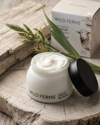 Wild Ferns skincare product on a wooden surface with packaging in the background