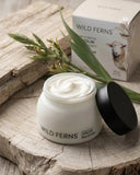 Wild Ferns skincare product on a wooden surface with packaging in the background
