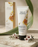 Wild Ferns facial moisturizer with packaging and flowers on a neutral background