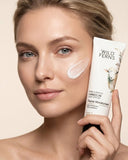 Woman applying Wild Ferns facial moisturizer to her face with a beige background