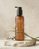 Brown bottle of Wild Ferns Manuka Honey Facial Wash on a stone surface with a natural background