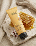 Wild Ferns Manuka Honey Face Mask with honeycomb and flowers on a stone surface