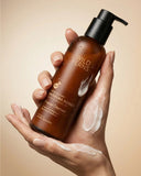 Hand holding a bottle of Wild Ferns facial cleanser with a beige background