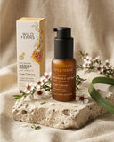 Wild Ferns Manuka Honey Eye Crème bottle and packaging on a stone surface with flowers.