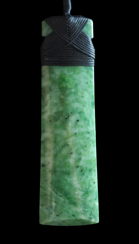 Green jade pendant with black cord on a black background Main image