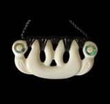 White bone necklace with black cord on a black background