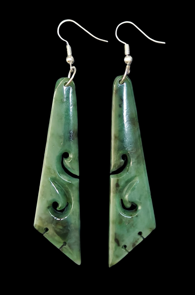 Pair of green jade earrings with intricate carvings on a black background