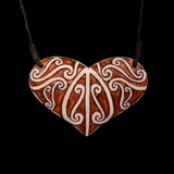 Heart-shaped pendant with intricate patterns on a black background