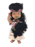 Doll with traditional Maori attire on a white background