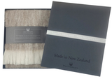 Woolen scarf with packaging displaying 'Made in New Zealand' on a white background
