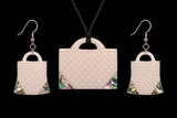 Set of handbag-shaped earrings and a matching necklace on a black background