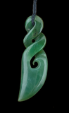 Green jade pendant with spiral design on a black background