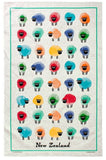 A white tea towel featuring a grid of colorful, hand-drawn sheep illustrations in red, blue, green, yellow, orange, and purple, framed by a teal border with 'New Zealand' printed at the bottom.
