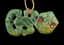 Green jade pendant with intricate carvings on a black background
