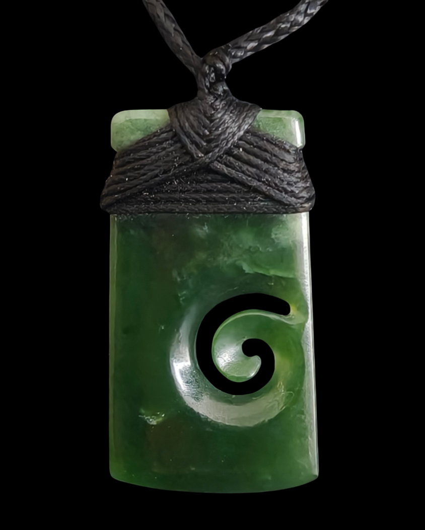 Green jade pendant with a spiral design on a black cord against a white background Main image