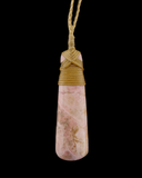 A pink and white marbled stone pendant with a natural teardrop shape, wrapped at the top with tan cord and hanging from a matching tan cord against a solid black background.