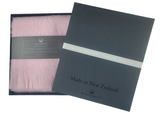 Pink scarf in a black box with 'Made in New Zealand' label