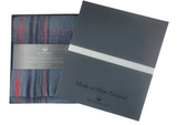 Plaid scarf with packaging and 'Made in New Zealand' label on a white background