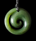 Greenstone spiral pendant on a black background