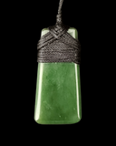 Green jade pendant on a black background