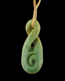 Green jade spiral pendant on a black background