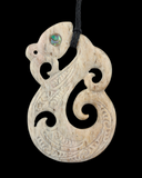 Carved bone pendant with intricate patterns on a black background